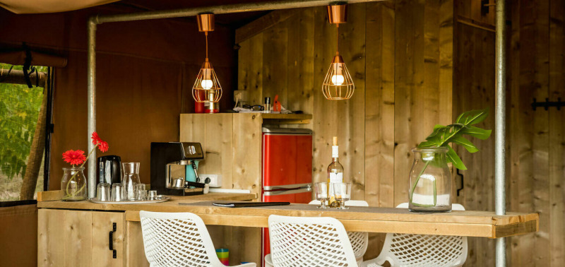 Cozy kitchen area in Desert Lodge safari tent at Camping Pian di Boccio, Italy, with wood and modern decor.