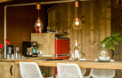 Cozy kitchen area in Desert Lodge safari tent at Camping Pian di Boccio, Italy, with wood and modern decor.