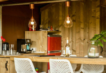 Coin cuisine chaleureux dans la tente safari Desert Lodge au Camping Pian di Boccio, Italie, décor bois moderne.