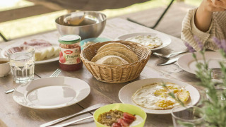 Mesa de desayuno en la tienda Safari Lodge de Camping Pian di Boccio, Italia, con pan, mermelada y huevos.