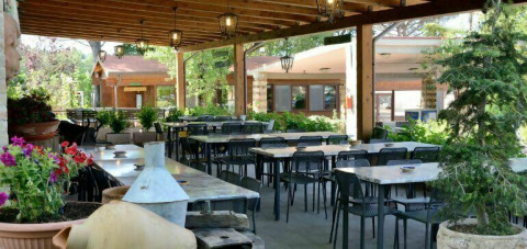 Overdekt terras met tafels en stoelen bij Camping Pian di Boccio in Umbrië, Italië.