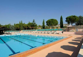 Piscina all’aperto con lettini e ombrelloni al Camping Pian di Boccio, villaggio vacanze in Umbria, Italia.