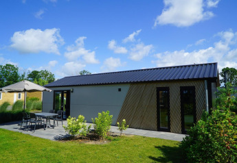 Moderne lodge Berkel bij EuroParcs Veluwemeer, Nederland, met terras, tuinmeubilair en groene tuin.