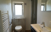 Moderne badkamer in de Berkel-lodge bij EuroParcs Veluwemeer, Nederland, met douche, raam en lavabo.
