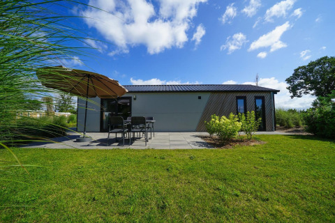 Lodge Berkel en EuroParcs Veluwemeer, Países Bajos, con terraza, muebles de exterior y jardín verde.