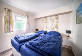 Slaapkamer met twee eenpersoonsbedden en blauwe dekbedden in Berkel lodge bij EuroParcs Veluwemeer.