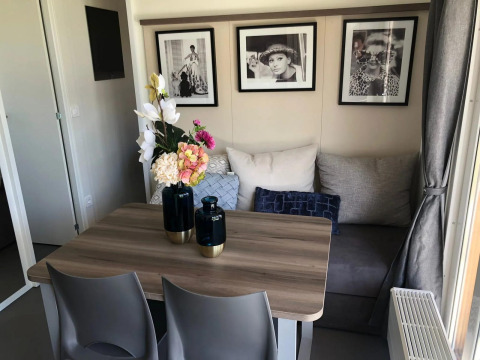 Comedor acogedor en Cosy Unique lodge en EuroParcs Veluwemeer, Países Bajos, con arte moderno en la pared.