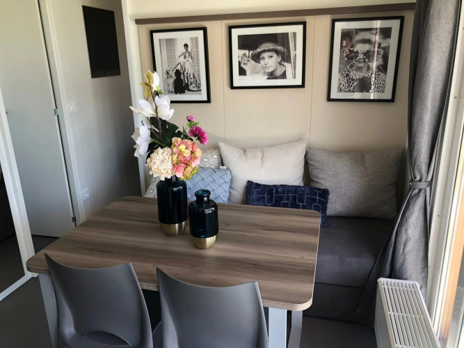 Comedor acogedor en Cosy Unique lodge en EuroParcs Veluwemeer, Países Bajos, con arte moderno en la pared.