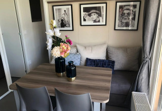 Et hyggeligt spiseområde i Cosy Unique-lodgen ved EuroParcs Veluwemeer, dekoreret med moderne kunst.