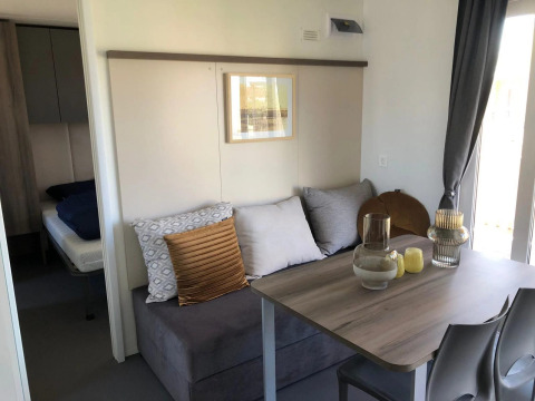 Sala y comedor de una lodge Cosy Unique en EuroParcs Veluwemeer con sofá, mesa y decoración moderna.