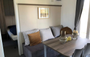 Stue og spiseplads i en lodge ved EuroParcs Veluwemeer med sofa, bord og moderne indretning.