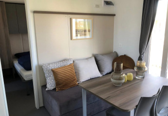 Woon- en eetkamer in een Cosy Unique lodge bij EuroParcs Veluwemeer met zetel en moderne inrichting.