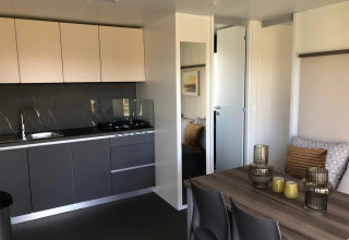 Cucina moderna e zona pranzo in una lodge Cosy Unique a EuroParcs Veluwemeer, Paesi Bassi, arredamento elegante.