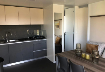 Moderne køkken og spiseområde i en lodge på EuroParcs Veluwemeer, med stilfuld indretning og dagslys.