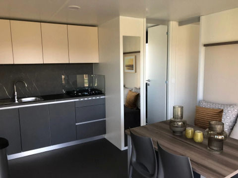 Cucina moderna e zona pranzo in una lodge Cosy Unique a EuroParcs Veluwemeer, Paesi Bassi, arredamento elegante.