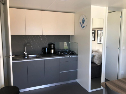 Modern kitchenette inside Cosy Unique lodge at EuroParcs Veluwemeer, Netherlands, with sleek grey cabinets.