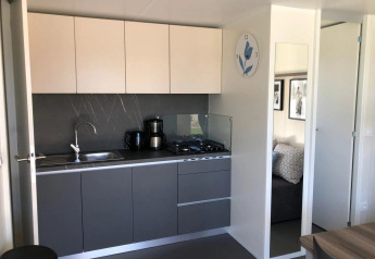 Moderne kitchenette in Cosy Unique lodge bij EuroParcs Veluwemeer, Nederland, met stijlvolle grijze kasten.