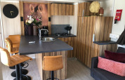 Interior de cocina moderna en la cabaña Cosy Unique, EuroParcs Veluwemeer, Países Bajos, con arte de cebra y taburetes.
