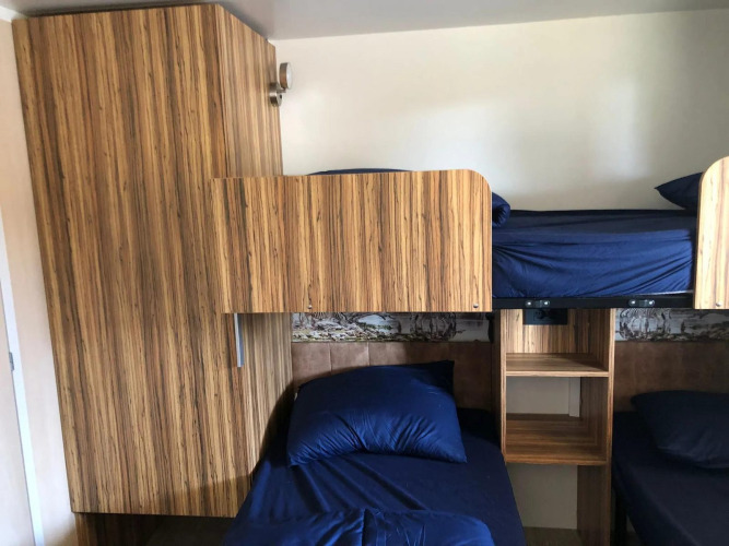 Habitación con literas y ropa de cama azul en Cosy Unique lodge en EuroParcs Veluwemeer, Países Bajos.