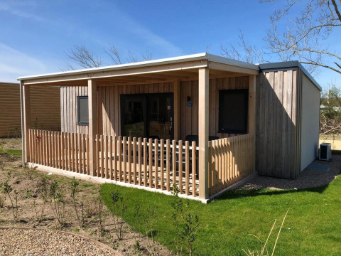Foto de una acogedora cabaña llamada Cosy Unique en EuroParcs Veluwemeer, Países Bajos, con terraza y jardín.