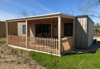 Billede af en hyggelig lodge ved navn Cosy Unique på EuroParcs Veluwemeer i Holland, med træterrasse.