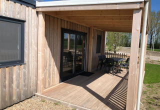 Terrasse ved en træhytte med udendørs bord og stole på EuroParcs Veluwemeer i Nederlandene