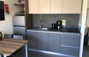 Cocina moderna en la lodge Cosy Unique de EuroParcs Veluwemeer, Países Bajos, con mesa y electrodomésticos.