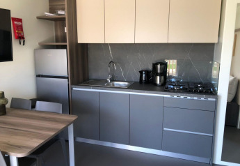 Cucina moderna nel lodge Cosy Unique presso EuroParcs Veluwemeer, Paesi Bassi, con tavolo e fornelli.
