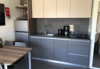 Cucina moderna nel lodge Cosy Unique presso EuroParcs Veluwemeer, Paesi Bassi, con tavolo e fornelli.