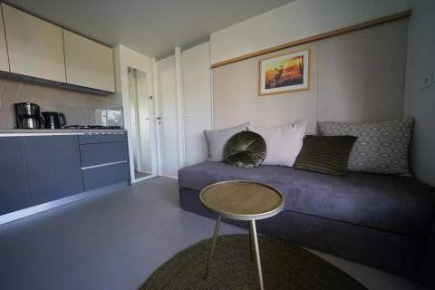 Salon moderne et coin cuisine élégamment décorés au lodge Cosy Unique d’EuroParcs Veluwemeer, Pays-Bas.