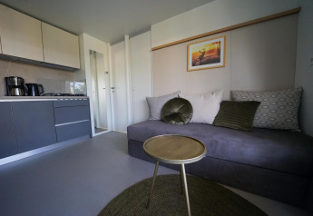Moderne stue og tekøkken med minimalistisk indretning på Cosy Unique lodge i EuroParcs Veluwemeer, Holland.