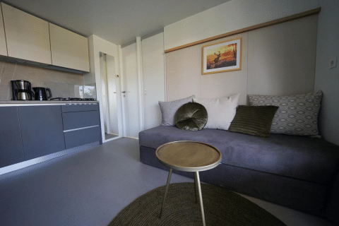 Moderne stue og tekøkken med minimalistisk indretning på Cosy Unique lodge i EuroParcs Veluwemeer, Holland.