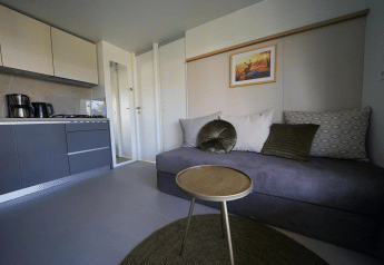 Sala moderna y cocina pequeña con decoración elegante en Cosy Unique lodge en EuroParcs Veluwemeer, Países Bajos.