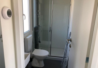Kleine badkamer in Cosy Unique lodge op EuroParcs Veluwemeer, Nederland, met douche en toilet.