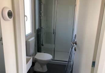 Lille badeværelse i lodge på EuroParcs Veluwemeer, Nederlandene, med brusebad, toilet og håndvask.
