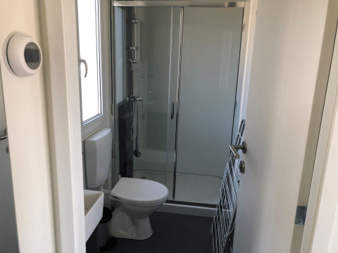 Kleine badkamer in Cosy Unique lodge op EuroParcs Veluwemeer, Nederland, met douche en toilet.