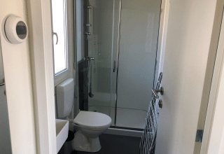 Baño pequeño en una cabaña Cosy Unique de EuroParcs Veluwemeer, Países Bajos, con ducha y aseo.