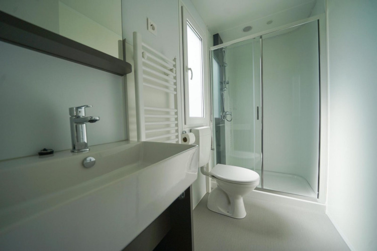 Baño moderno con ducha, inodoro y lavabo en Cosy Unique, EuroParcs Veluwemeer, Países Bajos.