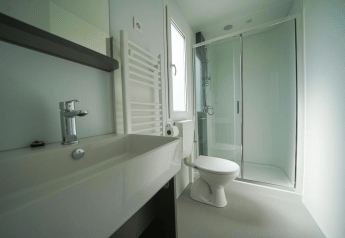 Baño moderno con ducha, inodoro y lavabo en Cosy Unique, EuroParcs Veluwemeer, Países Bajos.