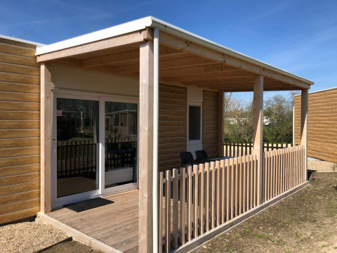 Een houten veranda met hekwerk bij de Cosy Unique lodge op EuroParcs Veluwemeer in Nederland.