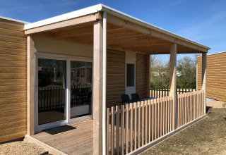 Terraza de madera con valla en la cabaña Cosy Unique en EuroParcs Veluwemeer, Países Bajos.