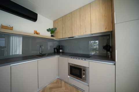 Moderne Küche in der Domus Lodge im EuroParcs Veluwemeer, Niederlande, mit Holzschränken und Geräten.