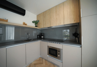 Cocina moderna en la cabaña Domus de EuroParcs Veluwemeer, Países Bajos, con muebles de madera y electrodomésticos.