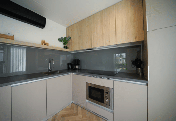 Moderne Küche in der Domus Lodge im EuroParcs Veluwemeer, Niederlande, mit Holzschränken und Geräten.