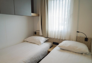 Habitación luminosa con dos camas individuales en Domus, EuroParcs Veluwemeer en Países Bajos.