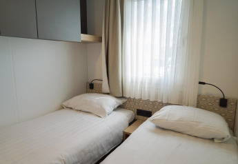 Heldere slaapkamer met twee aparte bedden in Domus, EuroParcs Veluwemeer in Nederland.