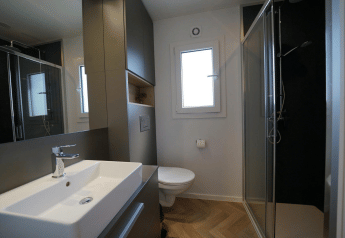 Modernes Badezimmer im Domus bei EuroParcs Veluwemeer in den Niederlanden mit Dusche und Waschbecken.