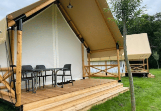 Tente safari glamping avec véranda en bois et mobilier extérieur à EuroParcs Veluwemeer, Pays-Bas.