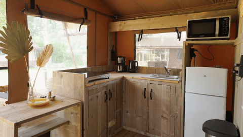 Cuisine glamping moderne en bois avec réfrigérateur, micro-ondes et fenêtres, Glampingtent Desert.