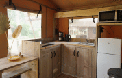 Cuisine glamping moderne en bois avec réfrigérateur, micro-ondes et fenêtres, Glampingtent Desert.